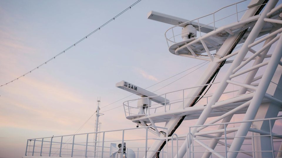 Radar antennas mounted on a ship against the sky.