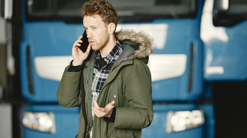 A person standing beside a blue truck, representing a mobile field deployment.