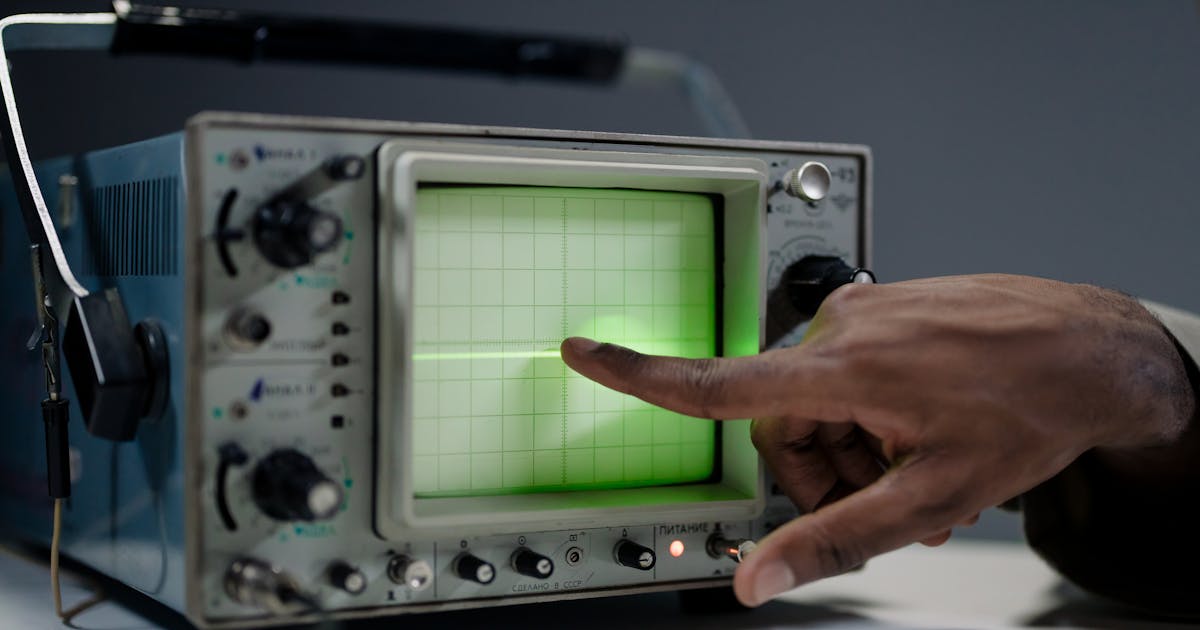 Engineer pointing at an oscilloscope screen during signal testing