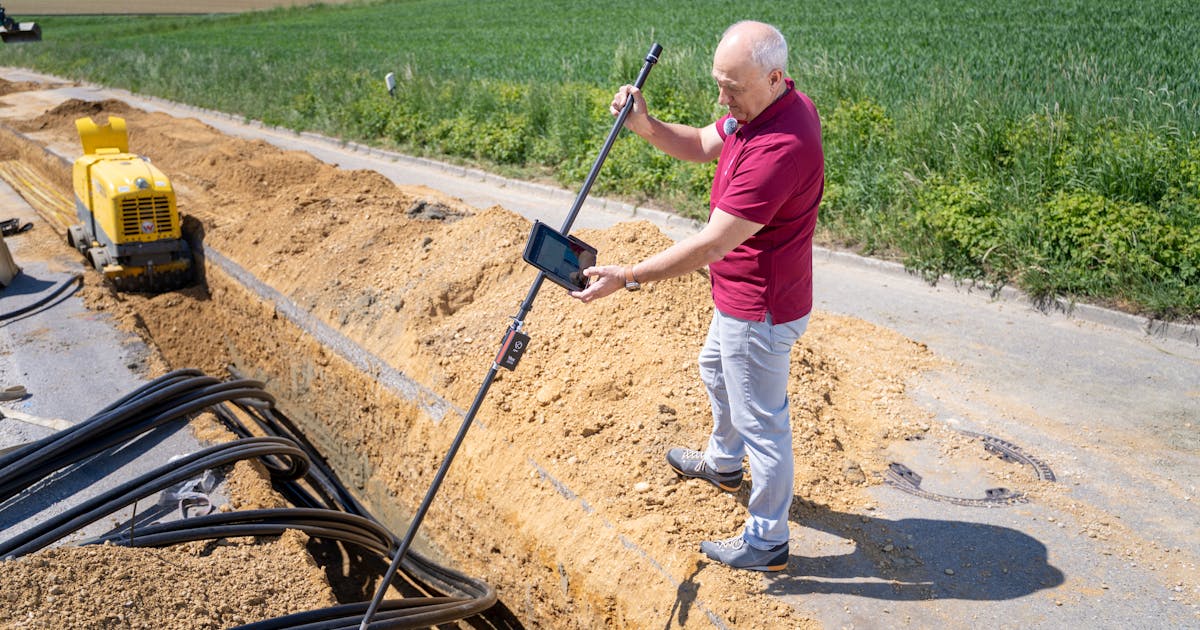 Engineer using surveying equipment at an outdoor construction site