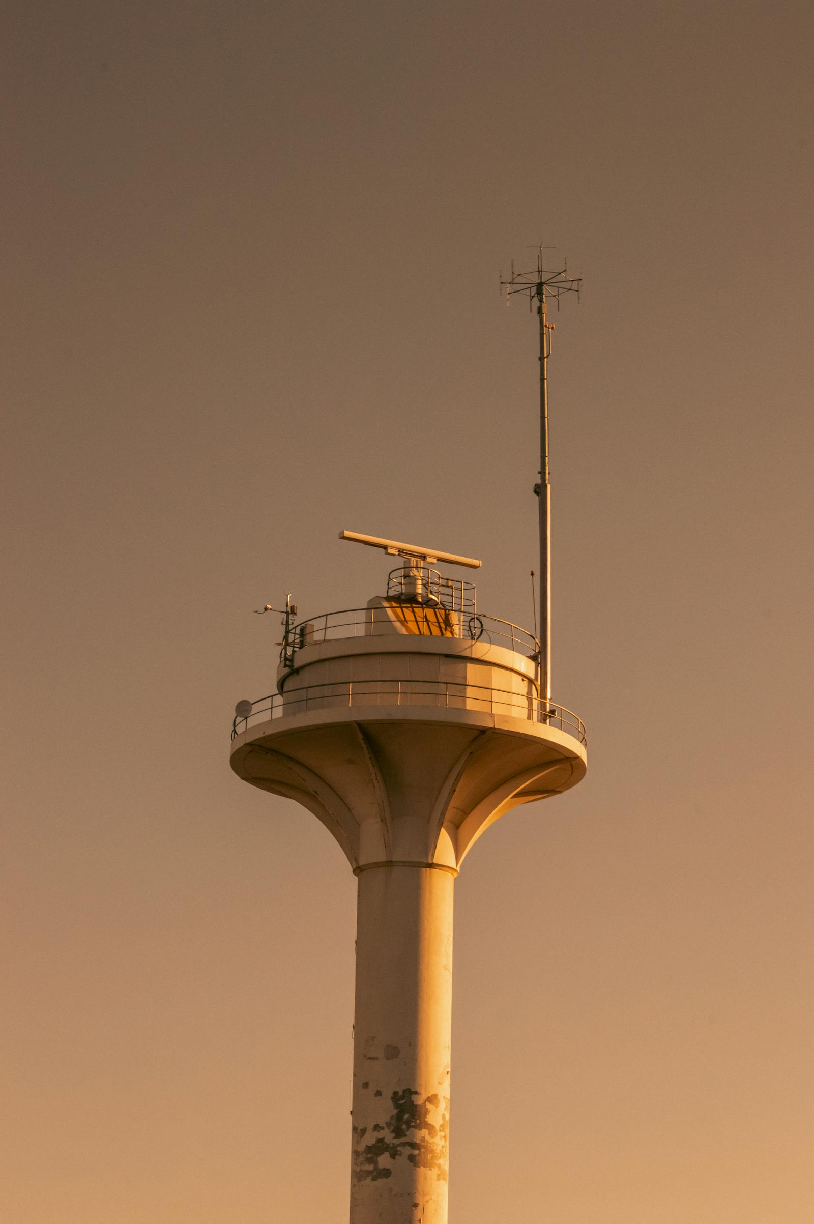 Radar antenna tower with communication equipment at sunset