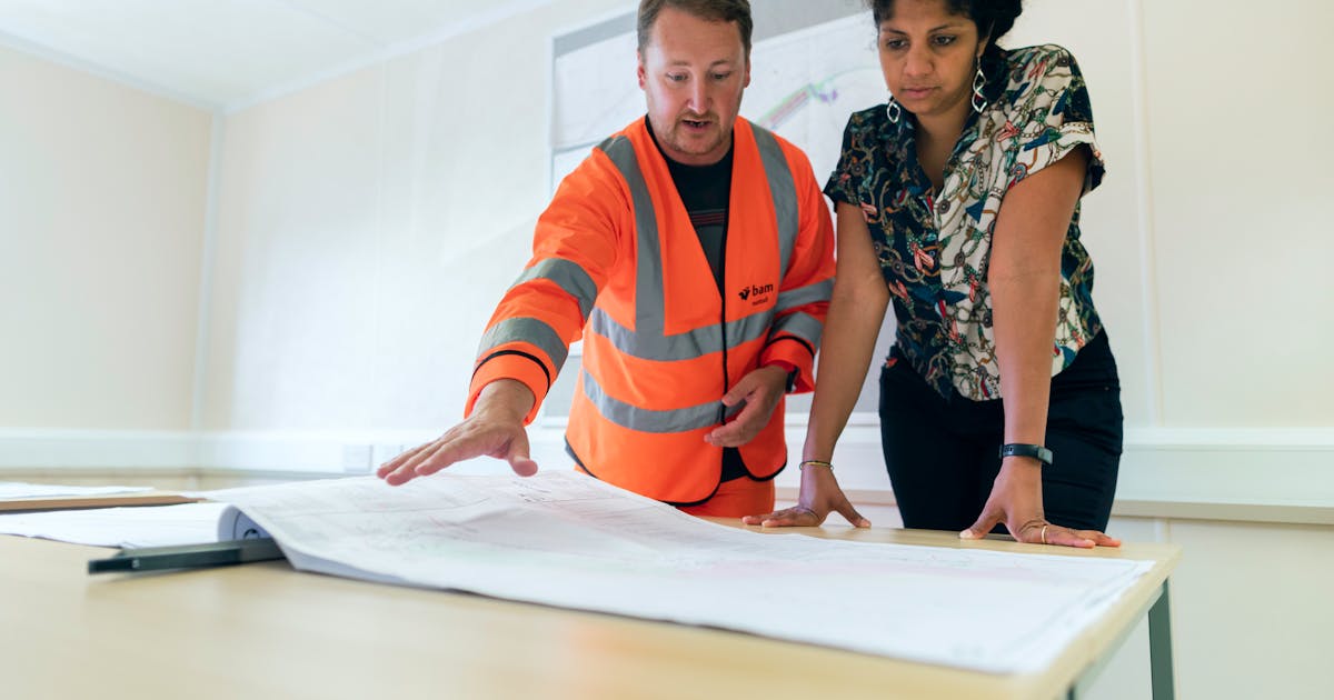 Engineers reviewing blueprints during project planning