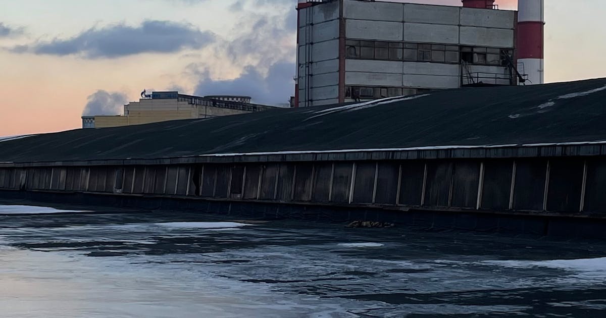 Industrial power plant with smokestacks at sunset